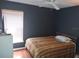 Well-lit bedroom with dark walls, ceiling fan, and comfortable queen-sized bed by the window at 15824 Green Cove Blvd, Clermont, FL 34714