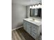 Bathroom featuring a white vanity with stylish hardware and a classic mirror with lighting at 311 James Ave, Auburndale, FL 33823