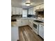 Bright kitchen with white cabinetry, light countertops, and wood plank backsplash at 311 James Ave, Auburndale, FL 33823