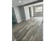 Spacious living room featuring new wood-look flooring, fresh paint, and ample natural light at 311 James Ave, Auburndale, FL 33823