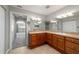 Bathroom featuring double sinks, wood cabinetry, neutral countertop, and tile flooring at 8166 Sw 80Th Ter, Ocala, FL 34476