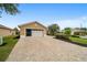Single story home featuring a two-car garage, long brick driveway and meticulously landscaped front yard at 8166 Sw 80Th Ter, Ocala, FL 34476