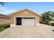 Two-car garage featuring carriage door with windows, a screened entry, and brick driveway at 8166 Sw 80Th Ter, Ocala, FL 34476