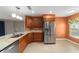 Kitchen with stainless steel refrigerator, wood cabinets, and granite countertops at 8166 Sw 80Th Ter, Ocala, FL 34476