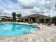 A community pool features a spacious deck with tables, chairs, umbrellas, and easy accessibility for all residents at 8166 Sw 80Th Ter, Ocala, FL 34476
