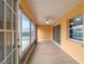 Enclosed sunroom featuring wood floors and ceiling fan, with multiple sliding glass doors leading to the outside at 8166 Sw 80Th Ter, Ocala, FL 34476