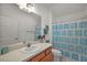 Bathroom featuring a vanity with sink, toilet, mirror, and blue-themed shower curtain at 1787 Foliage Ln, The Villages, FL 32162