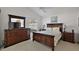 Comfortable bedroom with carpet flooring and dark wood furniture at 1787 Foliage Ln, The Villages, FL 32162