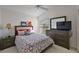 Cozy bedroom with a neutral color palette, ceiling fan, and a dresser with mirror at 1787 Foliage Ln, The Villages, FL 32162