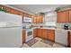 Functional kitchen with white appliances and wooden cabinets, perfect for everyday cooking at 1787 Foliage Ln, The Villages, FL 32162