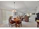 Open-concept living and dining area with neutral decor and access to the screened patio at 1787 Foliage Ln, The Villages, FL 32162