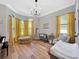 Charming Bedroom featuring wood floors, yellow curtains, a cozy chair, and a crib at 6567 Eagle Ridge Way, Lakeland, FL 33813