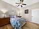 Cozy bedroom with blue and white bedding, ceiling fan, wood floors, and neutral walls at 6567 Eagle Ridge Way, Lakeland, FL 33813