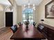 Formal dining room showcasing a large window, wooden floors, and a dining set illuminated by modern chandelier at 6567 Eagle Ridge Way, Lakeland, FL 33813
