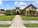 Charming home with red tile roof, arched entry, second story balcony, lush landscaping, and brick paver walkway at 6567 Eagle Ridge Way, Lakeland, FL 33813