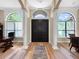 Inviting foyer with wood floors, arched doorway, decorative rug, and large windows with natural light at 6567 Eagle Ridge Way, Lakeland, FL 33813