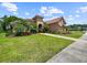 Attractive single-Gathering home featuring a tile roof, well-manicured lawn, shrubbery, and mature landscaping at 6567 Eagle Ridge Way, Lakeland, FL 33813