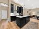 Kitchen with island, stone countertops, stainless steel appliances, and black cabinetry at 6567 Eagle Ridge Way, Lakeland, FL 33813