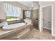 Luxurious bathroom with soaking tub, separate shower, and neutral tile at 6567 Eagle Ridge Way, Lakeland, FL 33813