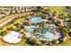 Beautiful aerial view of the luxurious community pool, splash pad, beach area and palm trees at 1450 Rolling Fairway Dr, Davenport, FL 33896
