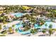 Aerial view of community pools, lazy river, water park and plentiful seating surrounded by tropical landscaping at 1450 Rolling Fairway Dr, Davenport, FL 33896