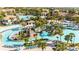 Stunning aerial view of the luxurious community pool, splash pad, and lounge seating surrounded by tropical landscaping at 1450 Rolling Fairway Dr, Davenport, FL 33896