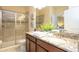 Well-lit bathroom featuring a granite vanity, tiled shower, and a mirrored door at 1450 Rolling Fairway Dr, Davenport, FL 33896