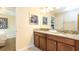 Bathroom featuring double sinks, granite countertops, and stylish mirrors, offering a luxurious experience at 1450 Rolling Fairway Dr, Davenport, FL 33896