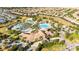 Stunning aerial view of community pool with palm trees, cabanas, and plenty of lounge seating for residents at 1450 Rolling Fairway Dr, Davenport, FL 33896