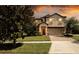 Charming two-story home with a brick driveway and well-manicured lawn at 1450 Rolling Fairway Dr, Davenport, FL 33896