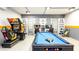 Fun game room with arcade machine, pool table, and interactive entertainment at 1450 Rolling Fairway Dr, Davenport, FL 33896