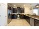 Modern kitchen with stainless steel appliances, dark wood cabinets, and stylish pendant lighting at 1450 Rolling Fairway Dr, Davenport, FL 33896