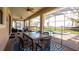 Covered patio with ceiling fans, elegant dining table, and cozy seating area overlooking the pool and lush backyard at 1450 Rolling Fairway Dr, Davenport, FL 33896