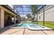 Beautiful screened in pool and spa with brick patio, string lights, and view of backyard perfect for entertaining and relaxing at 1450 Rolling Fairway Dr, Davenport, FL 33896