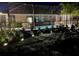 Backyard view with night lighting illuminating the landscaping and screened pool area, creating a serene atmosphere at 1568 Cordgrass Way, Lakeland, FL 33813