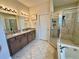 Bathroom featuring double sink vanity with granite countertop and walk-in shower at 1568 Cordgrass Way, Lakeland, FL 33813