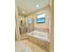 Bright bathroom showcasing a glass enclosed shower and soaking tub with tile surround at 1568 Cordgrass Way, Lakeland, FL 33813