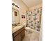 Bright bathroom features a granite-topped vanity and shower-tub combo at 1568 Cordgrass Way, Lakeland, FL 33813