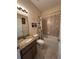 Bright bathroom features a granite-topped vanity and shower-tub combo at 1568 Cordgrass Way, Lakeland, FL 33813