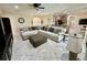Open-concept living room with neutral tones, tile floors, and adjacent kitchen area at 1568 Cordgrass Way, Lakeland, FL 33813