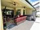 Cozy covered patio with comfortable seating, ceiling fans, TV, and a hot tub for outdoor relaxation at 1568 Cordgrass Way, Lakeland, FL 33813