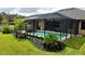 Screened-in lanai featuring a refreshing pool with tropical landscaping and a waterfall feature at 1568 Cordgrass Way, Lakeland, FL 33813