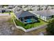 Aerial view of the screened in pool with a landscaped backyard and white privacy fence at 1568 Cordgrass Way, Lakeland, FL 33813