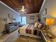 Comfortable bedroom with a wood-paneled ceiling, ceiling fan, and a decorative rug at 200 Maitland Ave # 114, Altamonte Springs, FL 32701