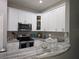 Modern kitchen featuring white cabinets, stainless steel appliances, and a luxurious marble countertop at 200 Maitland Ave # 114, Altamonte Springs, FL 32701