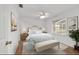 Bright bedroom with light wood flooring, ceiling fan, bench and natural light from the window at 2899 Sw 66 St, Ocala, FL 34476