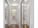 Hallway with doorways to a vanity area, bathroom and mirrored closets with hardwood floors at 2899 Sw 66 St, Ocala, FL 34476