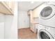 Bright laundry room features tile flooring, washer, dryer, and storage cabinets at 2899 Sw 66 St, Ocala, FL 34476