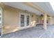 Covered patio with brick pavers, providing a shaded outdoor space with multiple access points to the home at 2899 Sw 66 St, Ocala, FL 34476