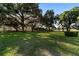 Sprawling property showcasing mature trees, a green lawn, and a classic wooden fence under a clear sky at 2899 Sw 66 St, Ocala, FL 34476